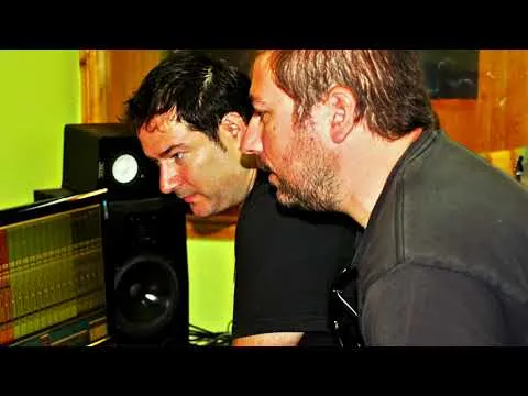 Dos músicos trabajando ante la mesa de mezclas de un estudio